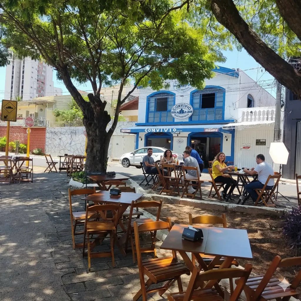 Mesas sob a árvore na calçada em frente ao Convívio