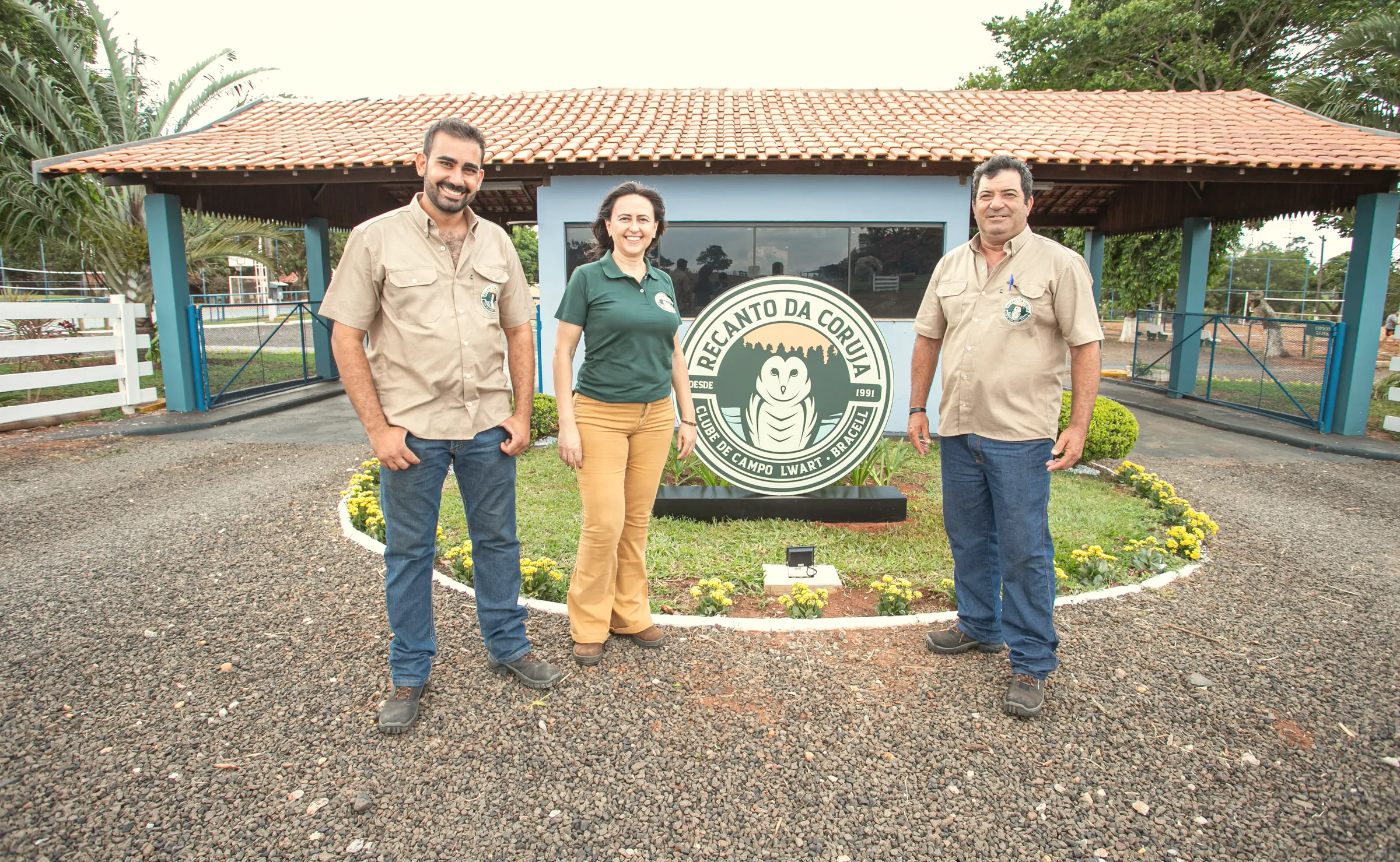 Equipe do clube ao lado do totem de entrada
