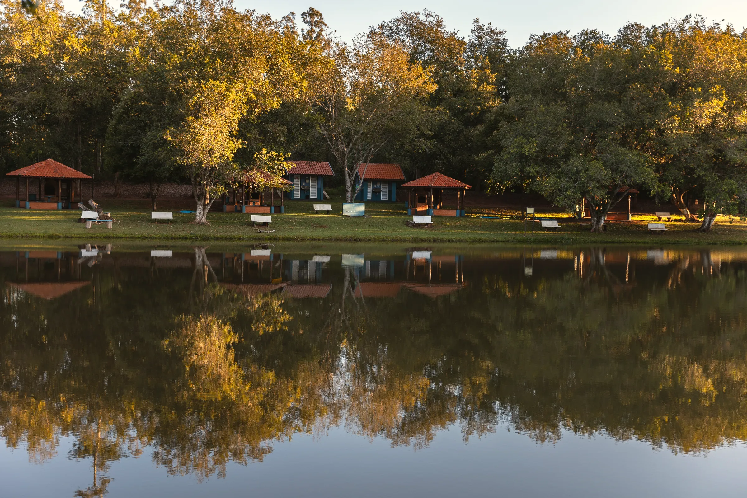 Construções de telhado vermelho refletidas na lagoa