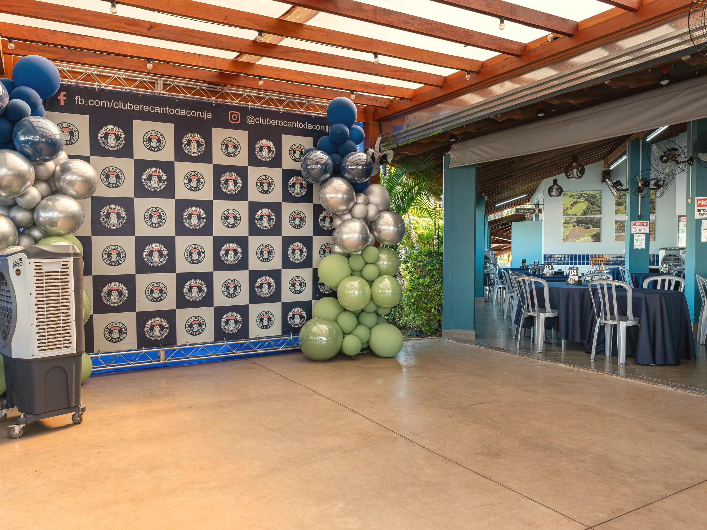 Painel de fundo com o selo repetido, montado para um evento no clube