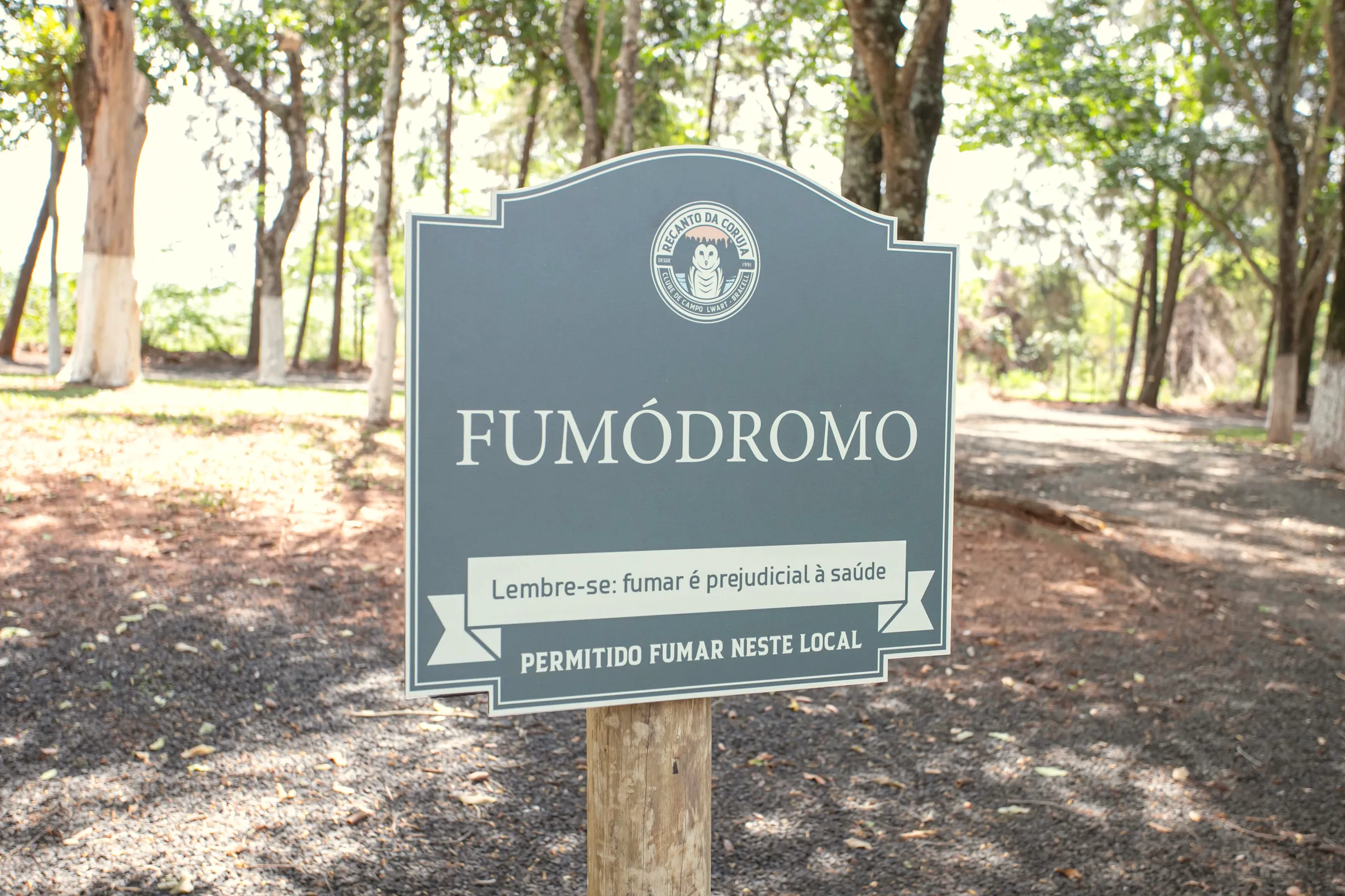 Placa do fumódromo no meio das árvores